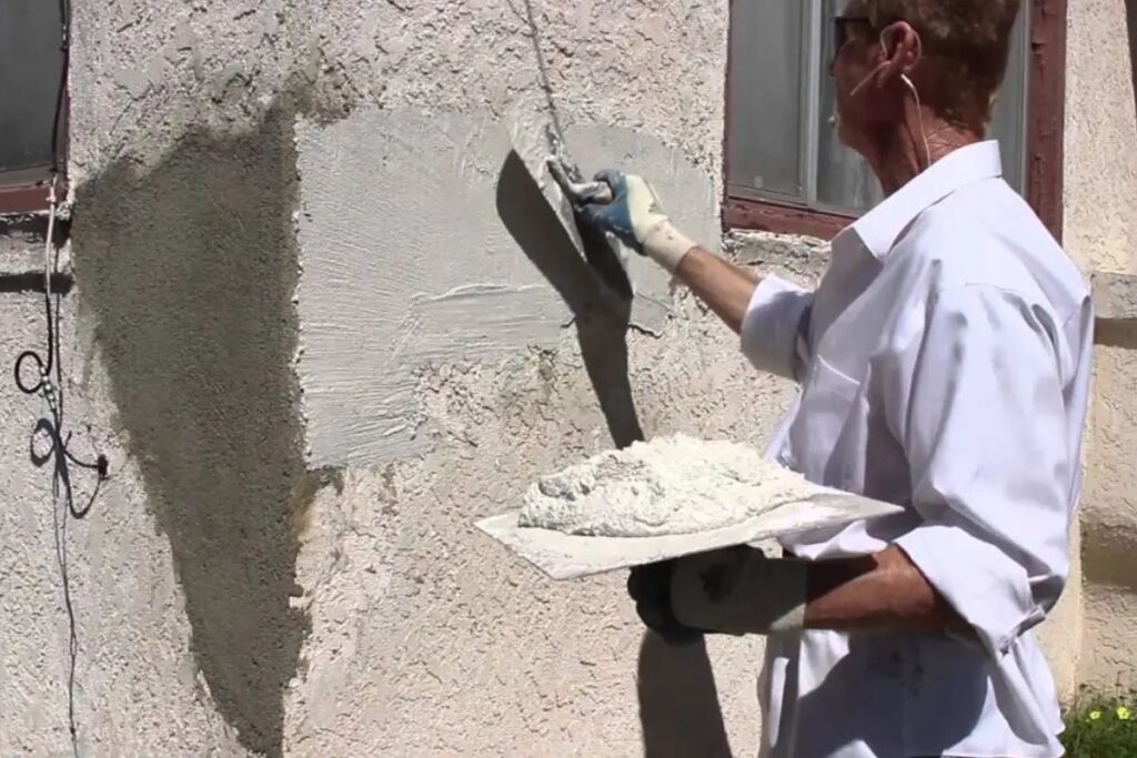 stucco contractor working on exterior stucco wall repair